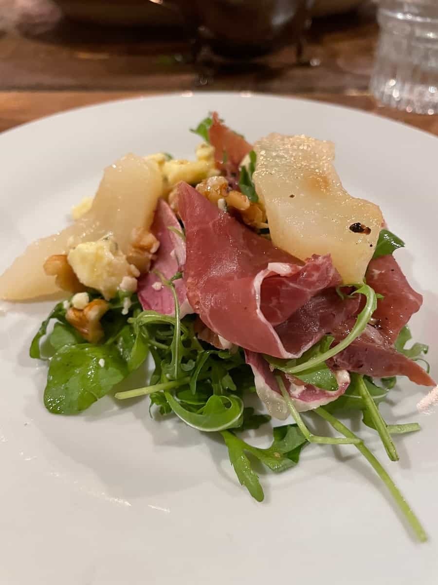 Winter endive and Parma Ham salad on a white plate