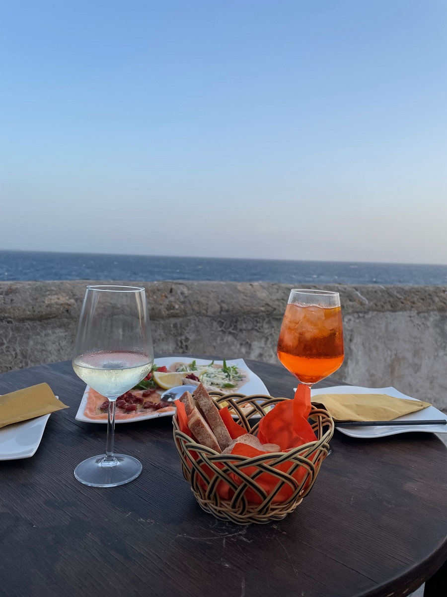 Drinks and a plate of food overlooking the sea